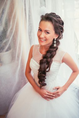 Güzel genç gelin düğün makyaj ve saç yatak, yeni evli kadın son hazırlık ve sunuş düğün için ile. Mutlu gelin bekleyen damat. Evlilik gün an düğün. portre yumuşak odak