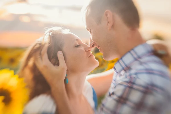 Schönes Paar hat Spaß in Sonnenblumenfeldern — Stockfoto