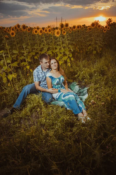 Hermosa pareja divirtiéndose en campos de girasoles — Foto de Stock