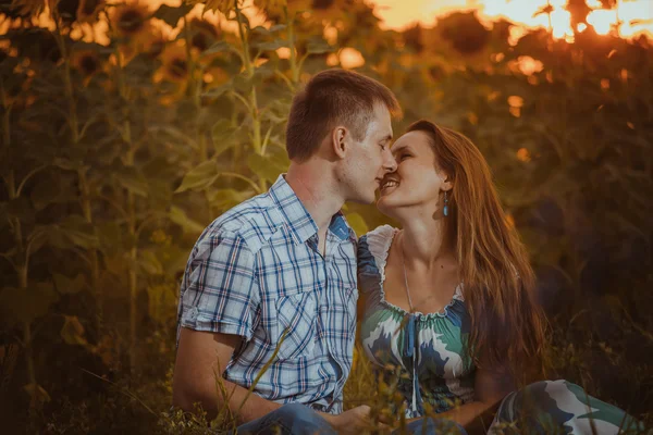 Mooi paar plezier in zonnebloemen velden — Stockfoto