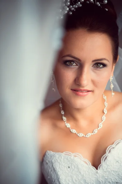Счастливая невеста смотрит в окно — стоковое фото