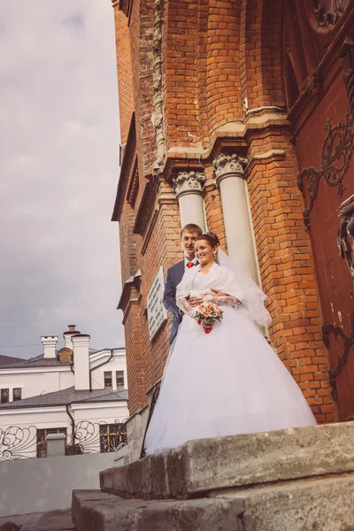 Een mooie bruid en knappe bruidegom op kerk tijdens huwelijk — Stockfoto