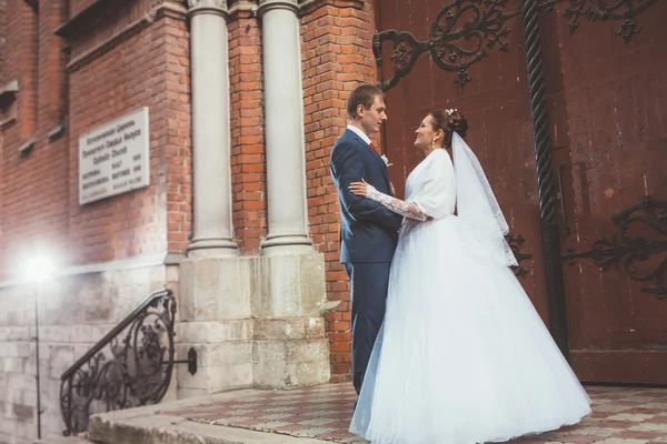 Krásná nevěsta a pohledný ženich v kostele během svatební — Stock fotografie