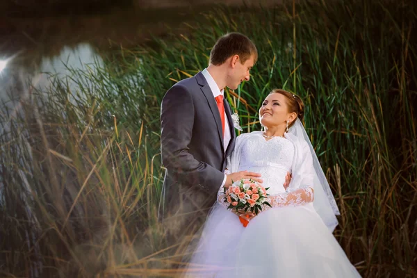 Beau beau couple nuptial debout près du lac — Photo