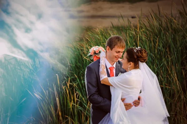 Prachtige mooie bruidspaar staande in de buurt van lake — Stockfoto