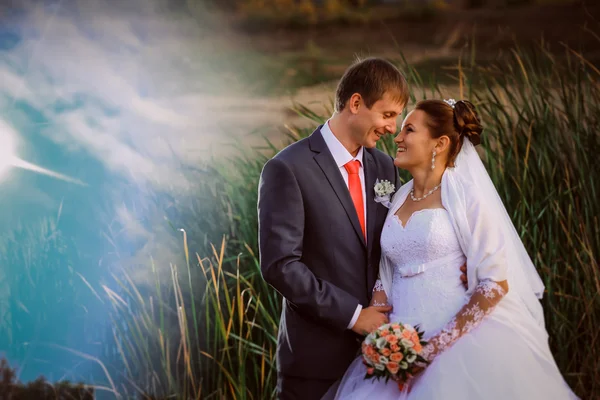 Beau beau couple nuptial debout près du lac — Photo