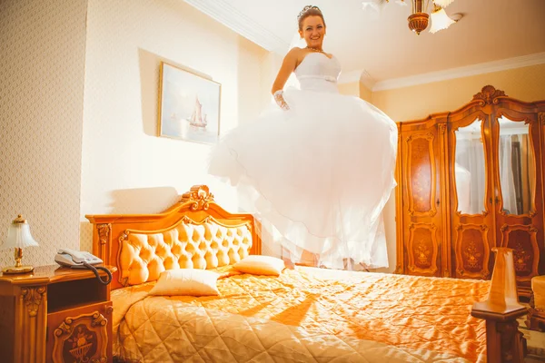 Szczęśliwa panna młoda skakać na łóżku. — Zdjęcie stockowe