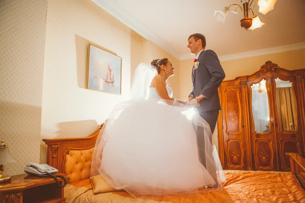 Gelin ve damat otel yatak üzerinde eğleniyor — Stok fotoğraf