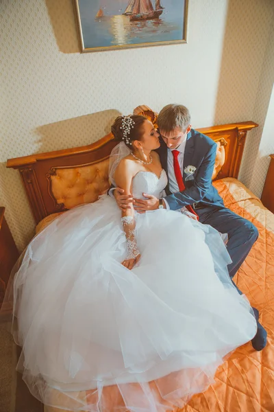 Свадебный снимок жениха и невесты, лежащих в стильной кровати — стоковое фото