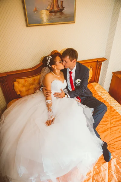 Wedding shot of bride and groom lying in a stylish bed — Stock Photo, Image