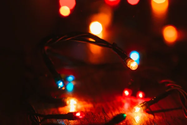 Luces de Navidad sobre fondo de madera. Enfoque selectivo — Foto de Stock