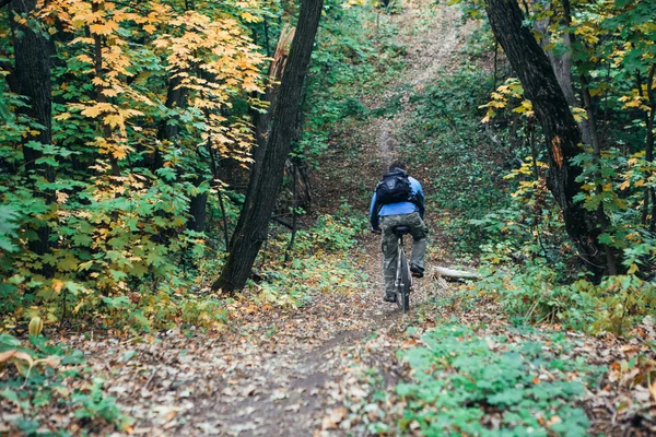 Человек с велосипедом в лесу — стоковое фото