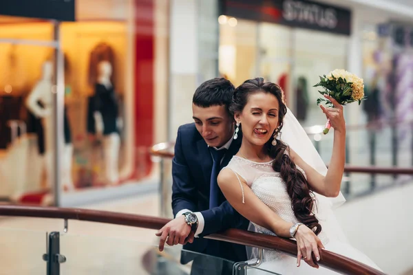 Glückliche Braut und Bräutigam umarmen sich im Einkaufszentrum — Stockfoto