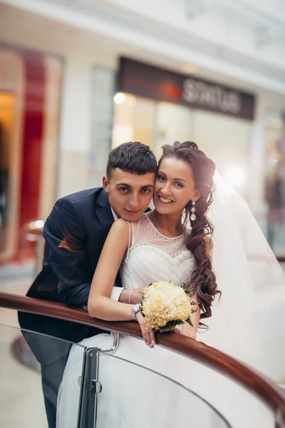 Gelukkige bruid en bruidegom omarmen in het winkelcentrum — Stockfoto