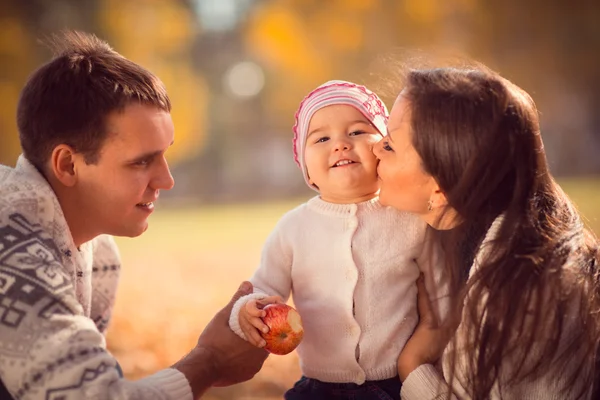 Gelukkige jonge familie tijd buiten doorbrengen in de herfst park — Stockfoto