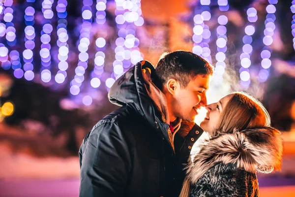 Jonge liefdevolle paar zoenen in een winter stad. — Stockfoto