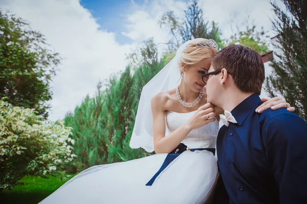 Bruden och brudgummen på bröllop ceramony nära träd på park / leende bruden och brudgummen. Vackra par i kärlek omfamna bruden och brudgummen. — Stockfoto