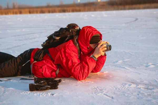 Fotógrafo tomar fotos en la orilla del río en invierno —  Fotos de Stock