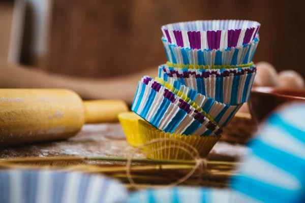 Impacchi di cupcake colorati con teglia su sfondo di legno — Foto Stock