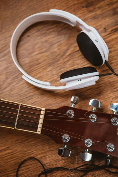 Acoustic guitar and headphone on fabric sofa — Stock Photo, Image