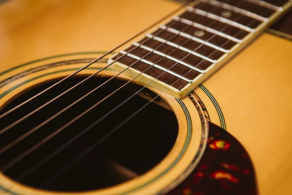 Macro shot down the fretboard of acoustic guitar with shallow depth of field — Stock Photo, Image