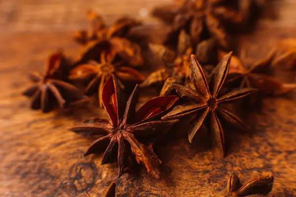 Paus de canela com anis estrela no fundo de madeira — Fotografia de Stock