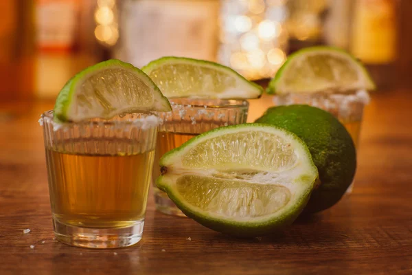 Tequila, lima y sal sobre mesa de madera — Foto de Stock