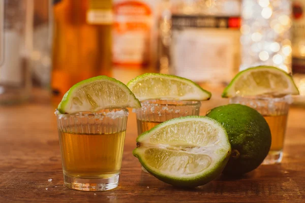 Tequila, lima y sal sobre mesa de madera —  Fotos de Stock