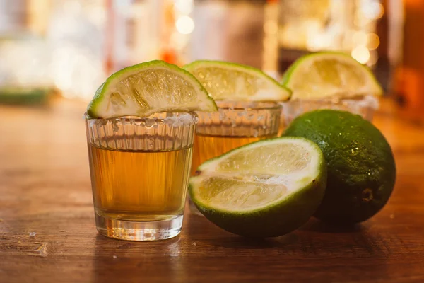 Tequila, kalk en zout op houten tafel — Stockfoto