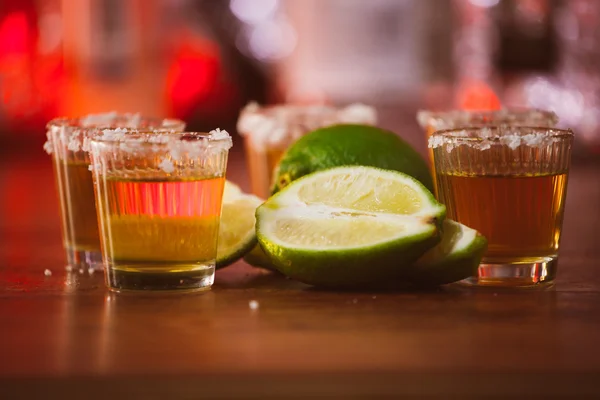 Tequila, limão e sal sobre mesa de madeira — Fotografia de Stock