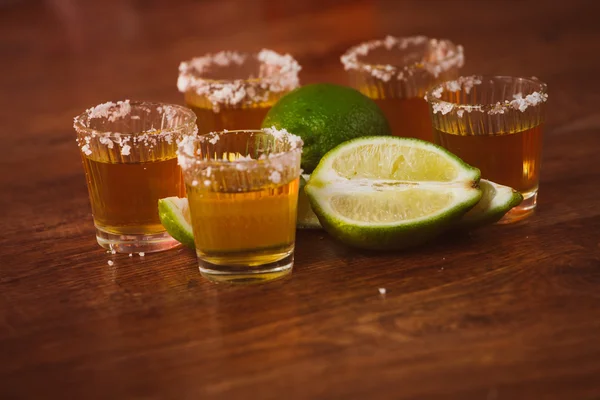 Tequila, cytryna i sól na drewnianym stole — Zdjęcie stockowe