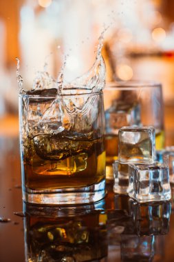 viski cam buz ve sıcak ışık yansıması, sıcak bir atmosfer ile siyah masada