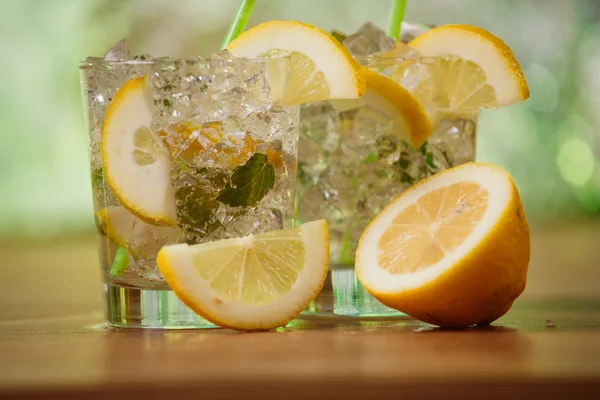 Lemonade with fresh lemon and mint by lemon reamer — Stock Photo, Image