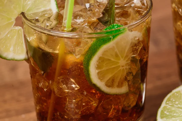 Conceito de bebida - coquetel com cubos de gelo de cola e limão — Fotografia de Stock