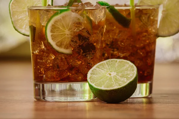 Drink koncept - cocktail med cola isbitar och lime — Stockfoto