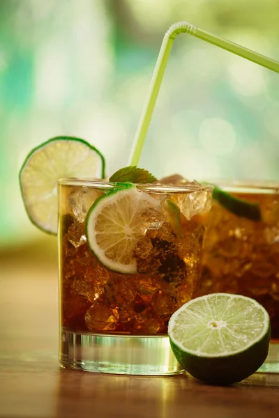 Drink concept - cocktail with cola ice cubes and lime — Stock Photo, Image