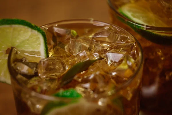 Drink koncept - cocktail med cola isbitar och lime — Stockfoto