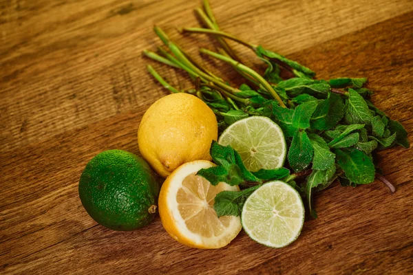 Agrumes frais mûrs à la menthe sur table en bois de jardin — Photo