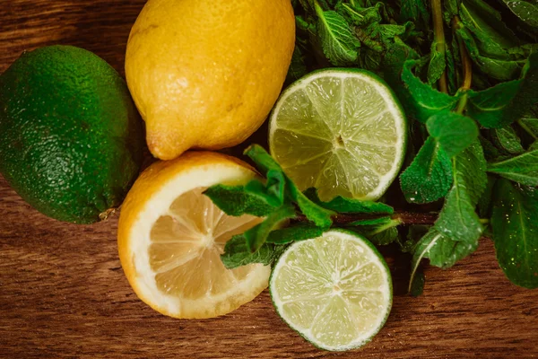 Agrumes frais mûrs à la menthe sur table en bois de jardin — Photo