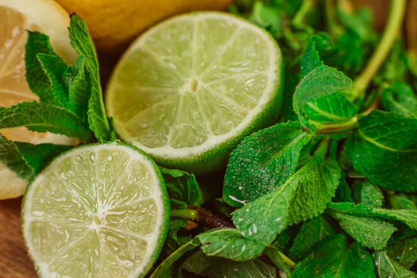 Färska mogna citrusfrukter med mynta på trädgård bord av trä — Stockfoto