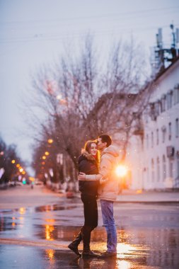 Sonbahar yağmurlu bir gün içinde öpüşme genç güzel çift portresi.