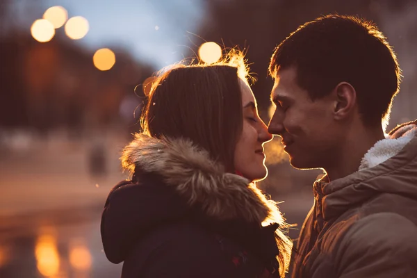 Bell'uomo che abbraccia la sua ragazza sulla panchina nel parco autunnale di notte — Foto Stock