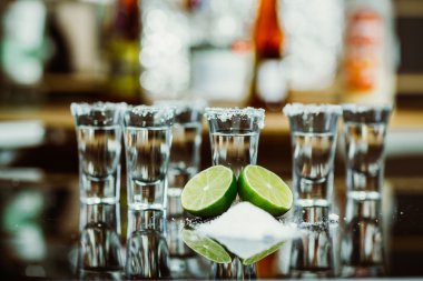 tekila limon ve tuz bir ahşap masa çubuğu parlak ışık çubuğunun arkaplanını'iki kurşun