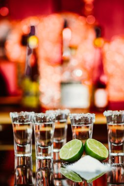 tekila limon ve tuz bir ahşap masa çubuğu parlak ışık çubuğunun arkaplanını'iki kurşun