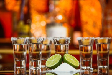 tekila limon ve tuz bir ahşap masa çubuğu parlak ışık çubuğunun arkaplanını'iki kurşun