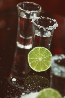 tekila limon ve tuz bir ahşap masa çubuğu parlak ışık çubuğunun arkaplanını'iki kurşun