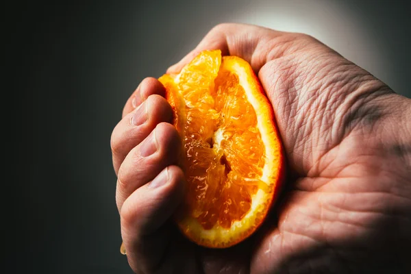 Man dramatic squeezes orange. Conceptis tired from work. — Stock Photo, Image