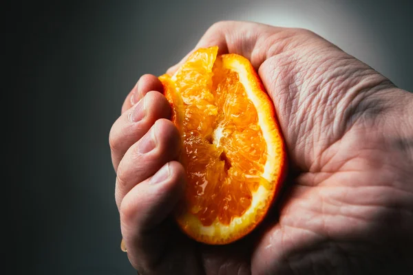 Man dramatic squeezes orange. Conceptis tired from work. — Stock Photo, Image