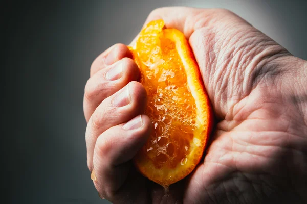 Man dramatic squeezes orange. Conceptis tired from work. — Stock Photo, Image