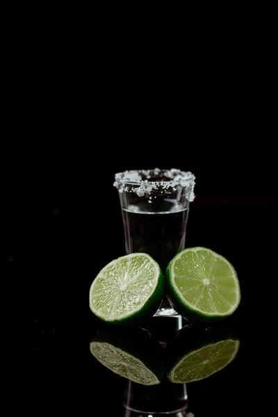 Tequila com limão sobre fundo preto — Fotografia de Stock